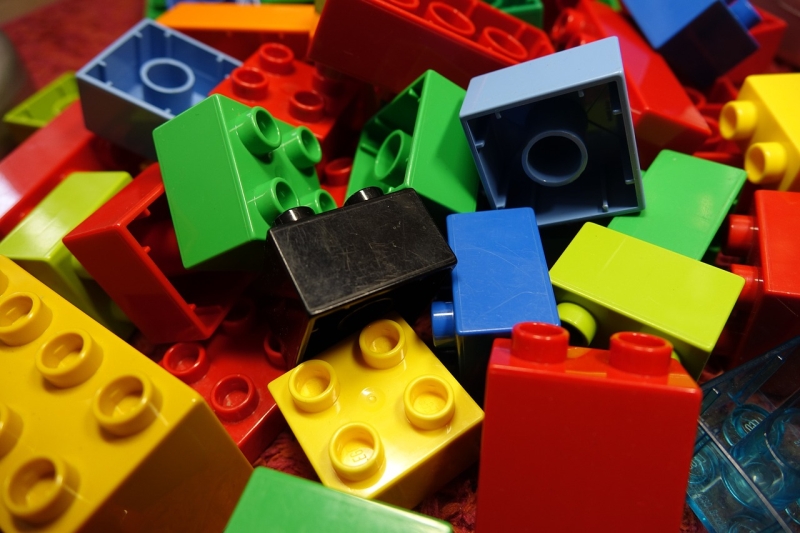 Close up of LEGO building blocks in black, blue, yellow, red, green, and orange